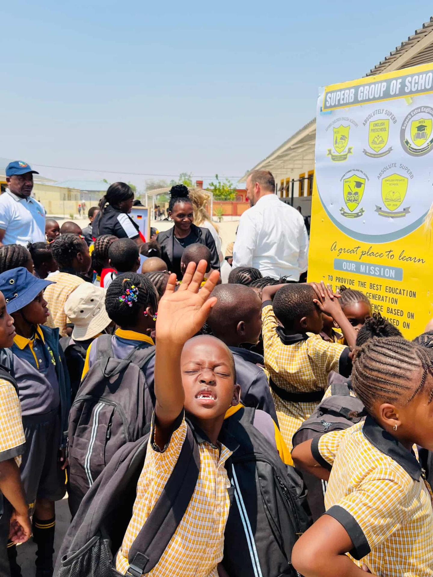 Learners in yellow checked uniforms gathered at a Superb Group of Schools assembly