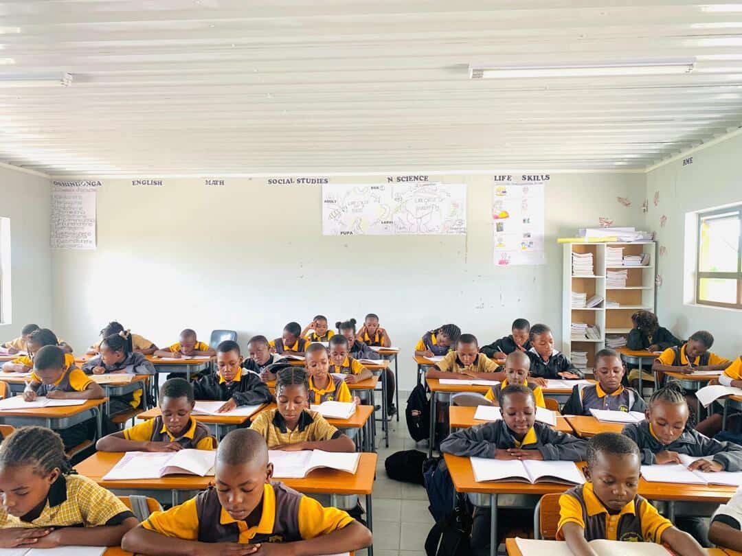 A full classroom of learners working quietly at their desks