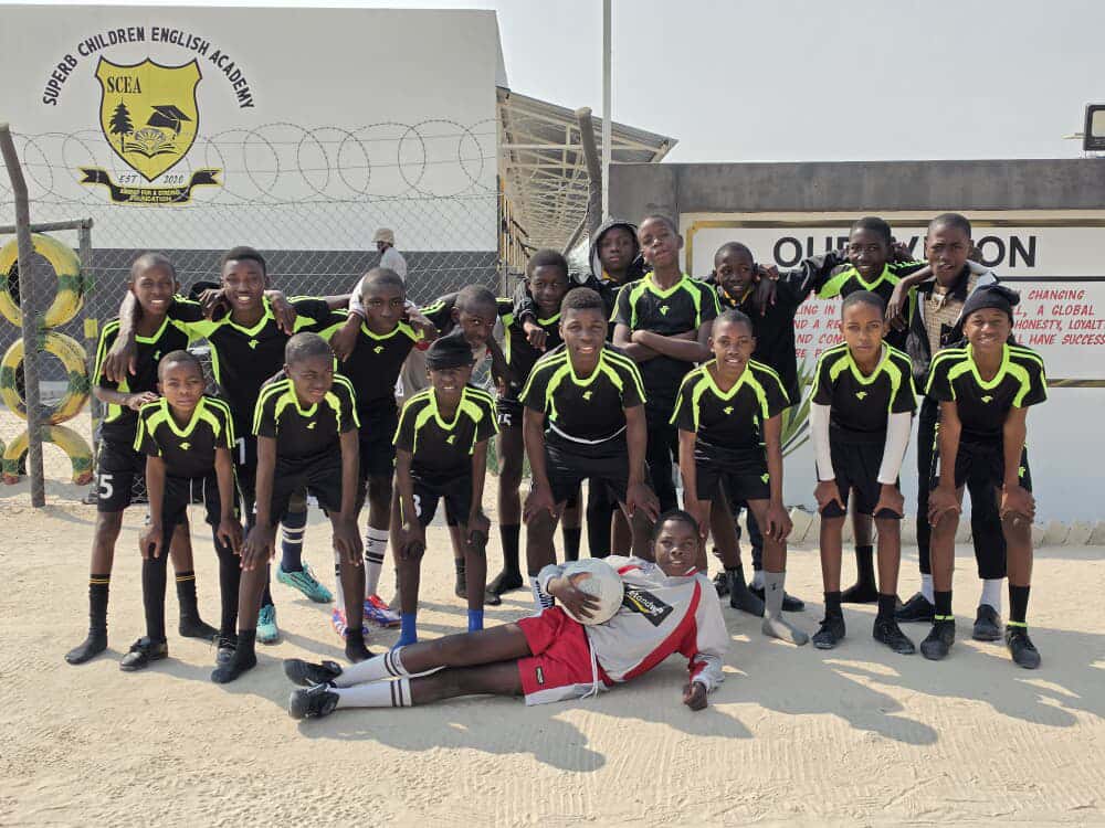 Superb Children English Academy soccer team posing at the school gate