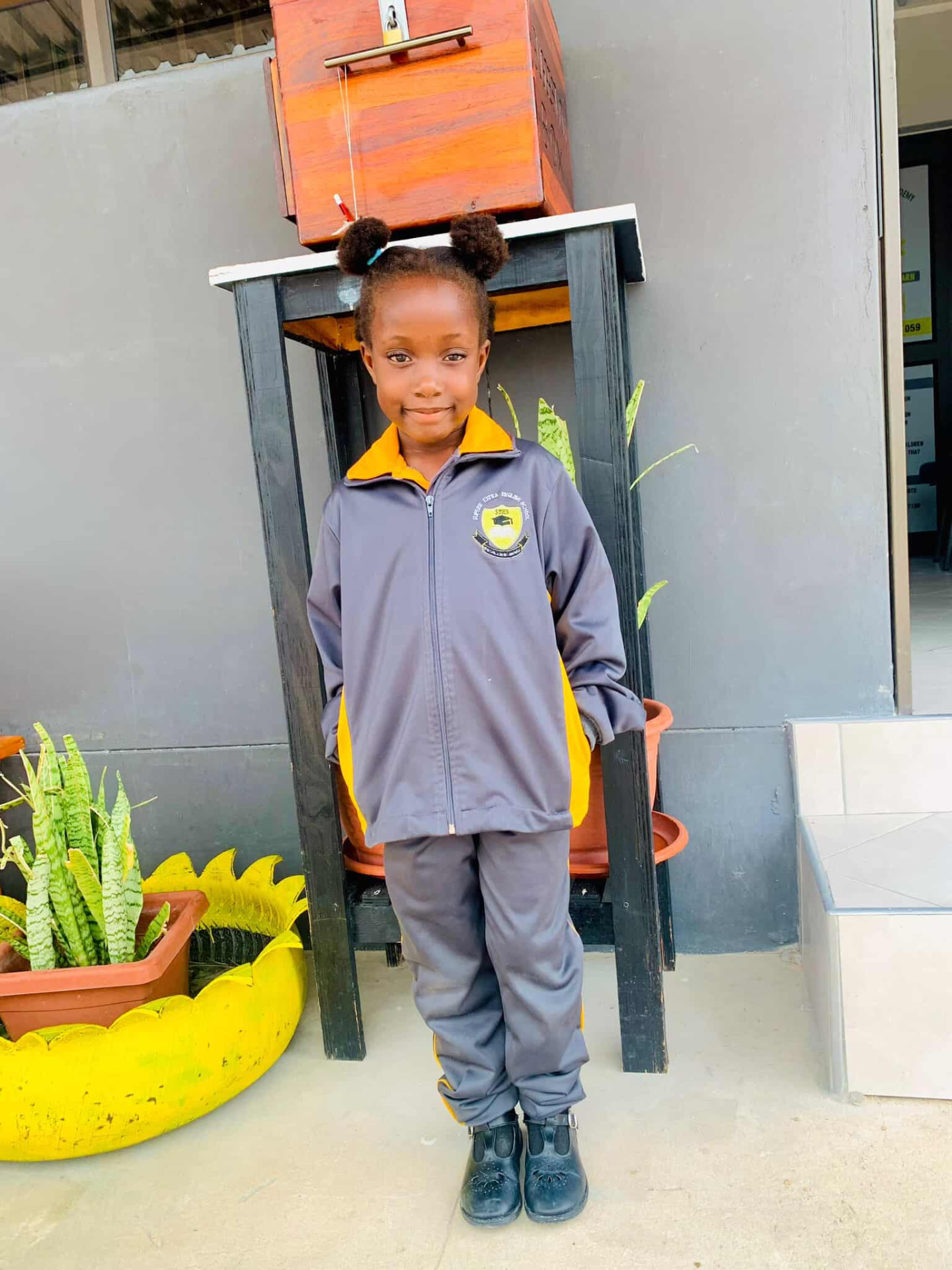 Preschool learner in a Superb Extra English School tracksuit standing outside the classroom